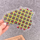 Rankoje laikomas pilnai išsiuvinėtas veltinio Lietuvos žemėlapis su geometriniu langelių raštu iš geltonų, žalių ir raudonų siūlų.